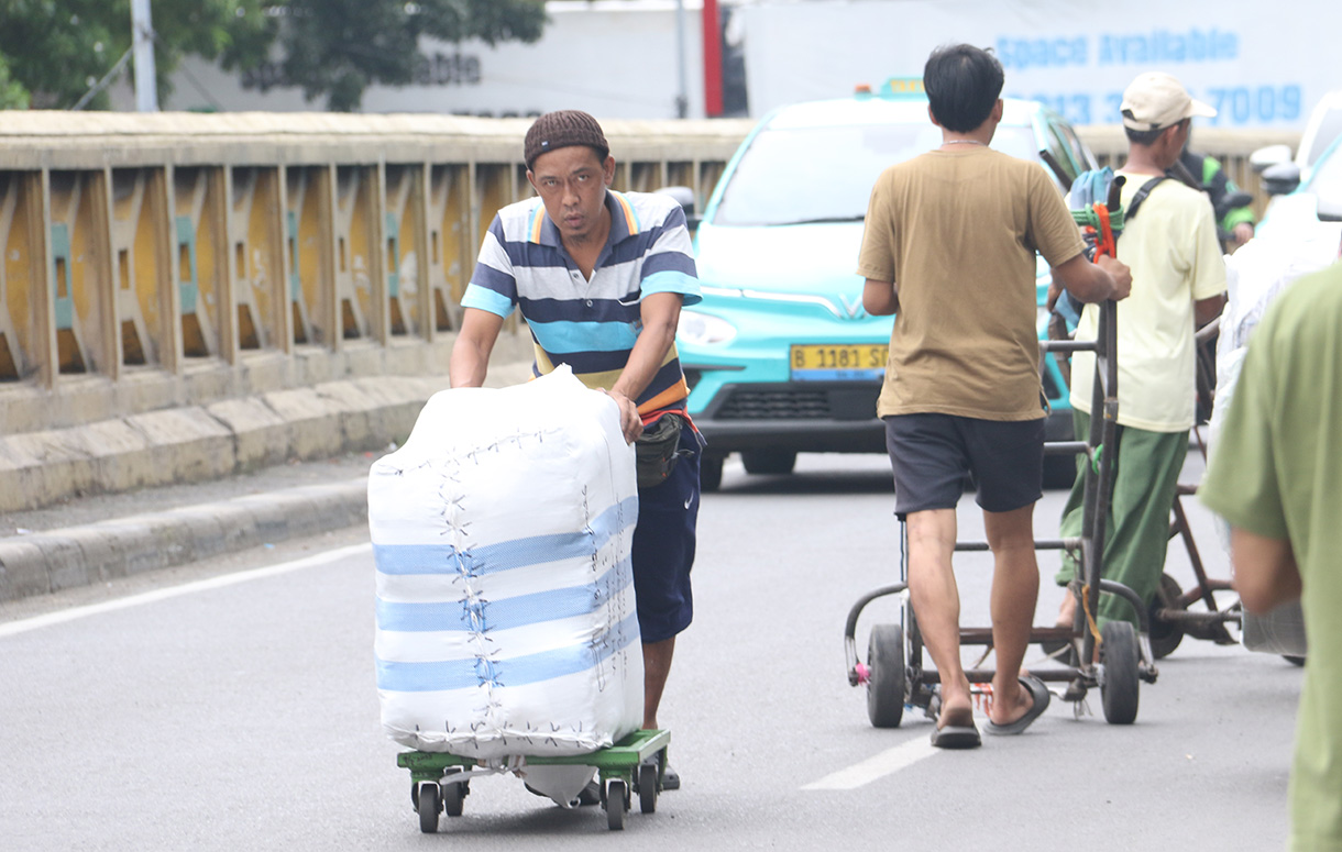 Buruh angkut membawa barang di kawasan Pasar Tanah Abang, Jakarta, Kamis (26/2/2025).(Beritanasional.com/Oke Atmaja)