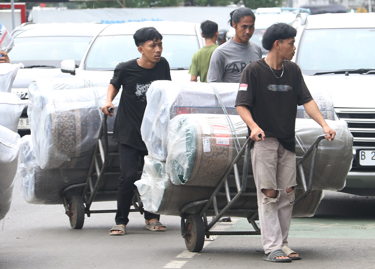 Buruh angkut membawa barang di kawasan Pasar Tanah Abang, Jakarta, Kamis (26/2/2025).(Beritanasional.com/Oke Atmaja)