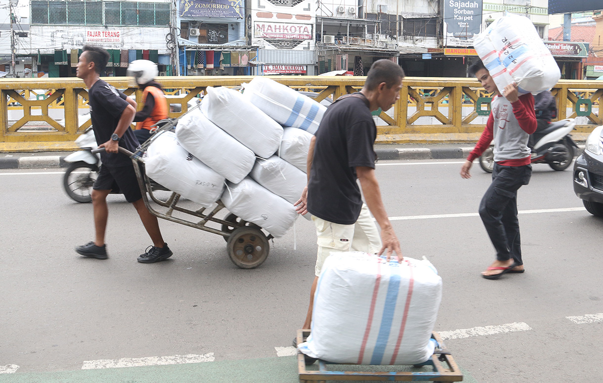 Buruh angkut membawa barang di kawasan Pasar Tanah Abang, Jakarta, Kamis (26/2/2025).(Beritanasional.com/Oke Atmaja)