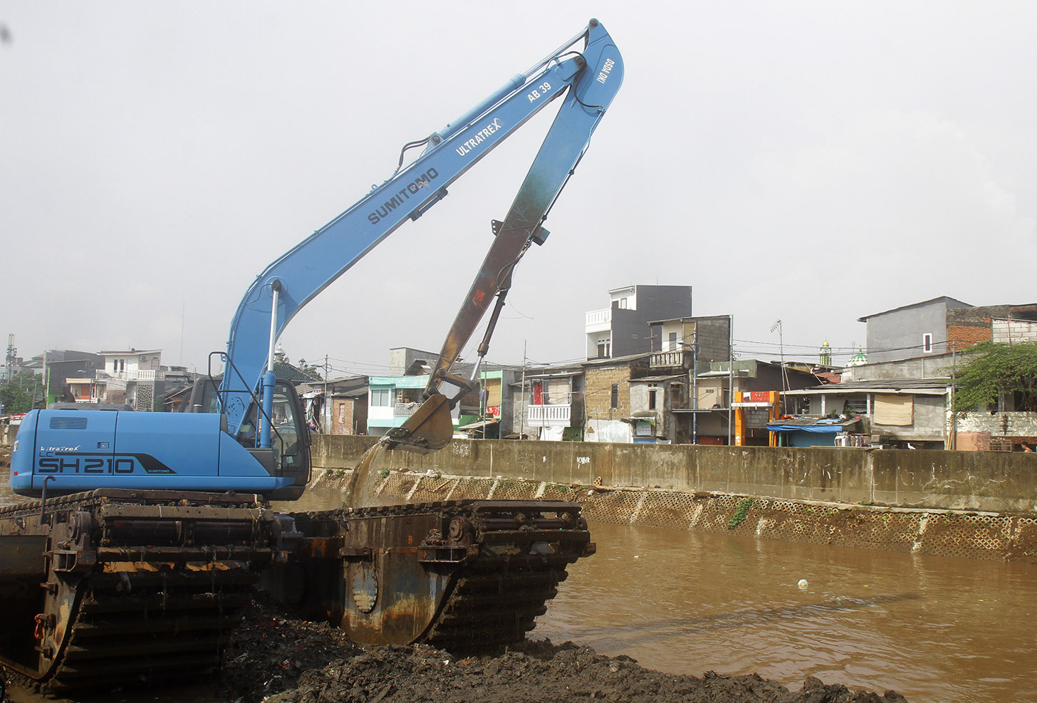 Alat berat mengeruk endapan sampah bercampur lumpur di Sungai Ciliwung kawasan Jatinegara, Jakarta, Rabu (3/7/2024).(BeritaNasional.com/Oke Atmaja)