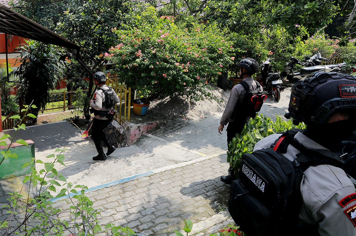 Personel Gegana Brimob Polda Metro Jaya berjaga saat proses penyisiran setelah adanya ancaman dugaan teror bom di SDN Srengseng Sawah 15 Pagi, Jagakarsa, Jakarta, Senin (13/7/2026). (Beritanasional.com/Oke Atmaja)