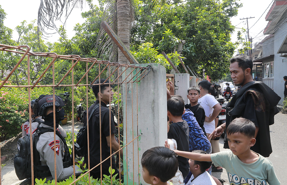 Personel Gegana Brimob Polda Metro Jaya berjaga saat proses penyisiran setelah adanya ancaman dugaan teror bom di SDN Srengseng Sawah 15 Pagi, Jagakarsa, Jakarta, Senin (13/7/2026). (Beritanasional.com/Oke Atmaja)