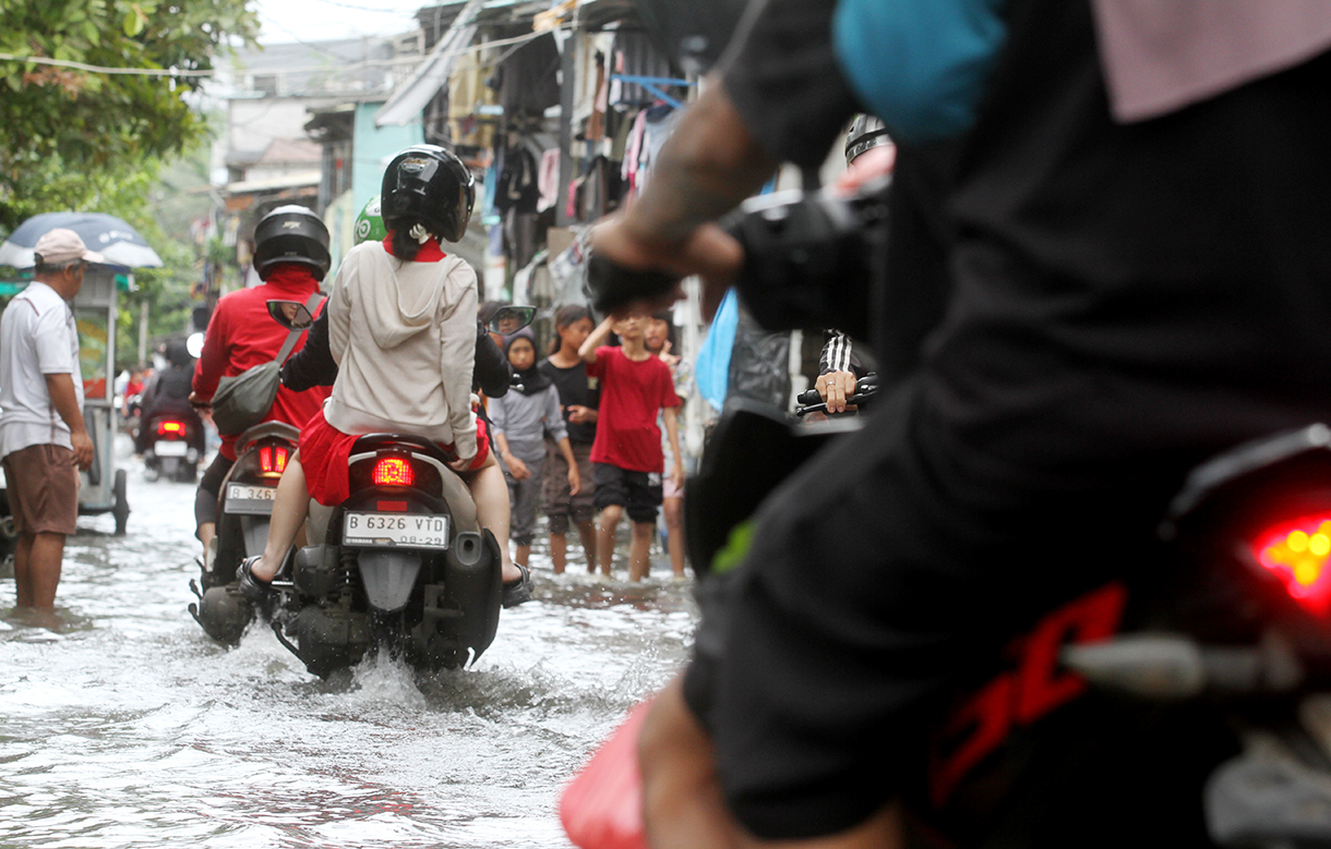 Warga menunggu warungnya di tengah banjir di Jelambar, Jakarta, Selasa (29/1/2025).(BeritaNasional/Oke Atmaja)