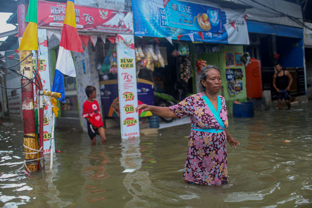 Sejumlah warga berjalan saat banjir rob di kawasan Muara Angke, Jakarta, Selasa (19/11/2024).  (Berita Nasional.Com/Oke Atmaja)