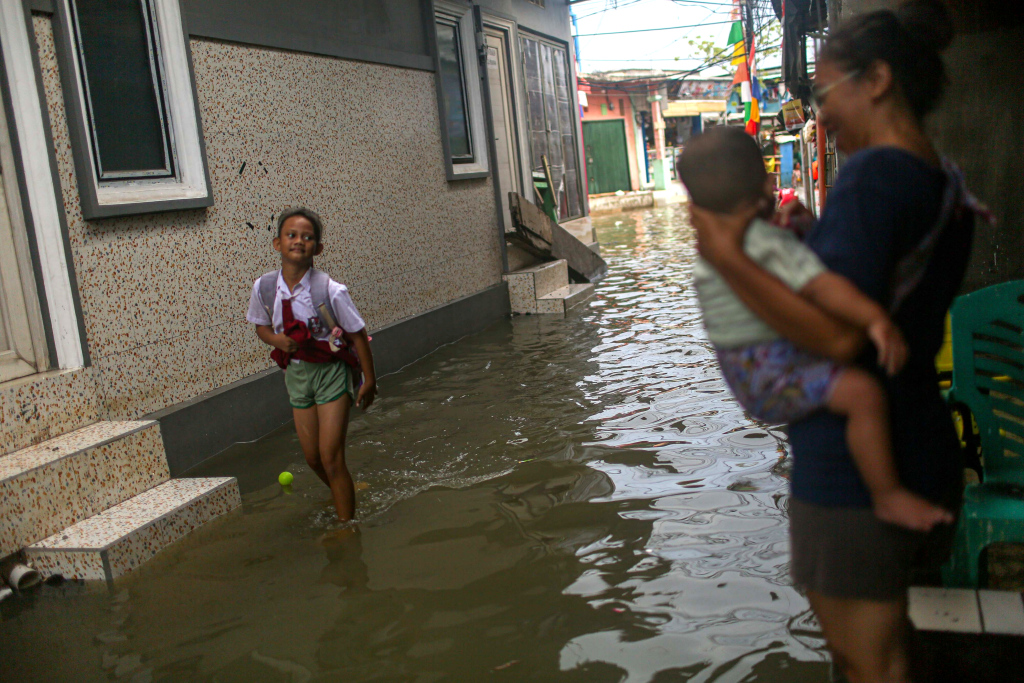 Sejumlah warga berjalan saat banjir rob di kawasan Muara Angke, Jakarta, Selasa (19/11/2024).  (Berita Nasional.Com/Oke Atmaja)