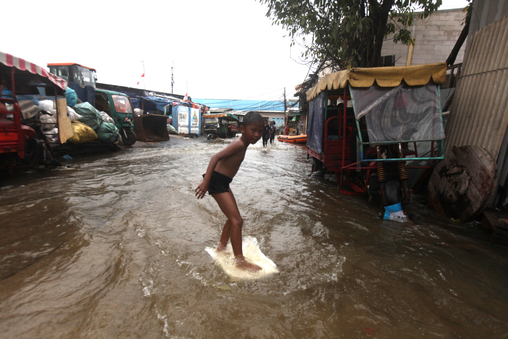 Sejumlah anak bermain di tengah banjir rob di Muara Angke, Jakarta, Senin (16/12/2024).  (Berita Nasional.com/Oke Atmaja)