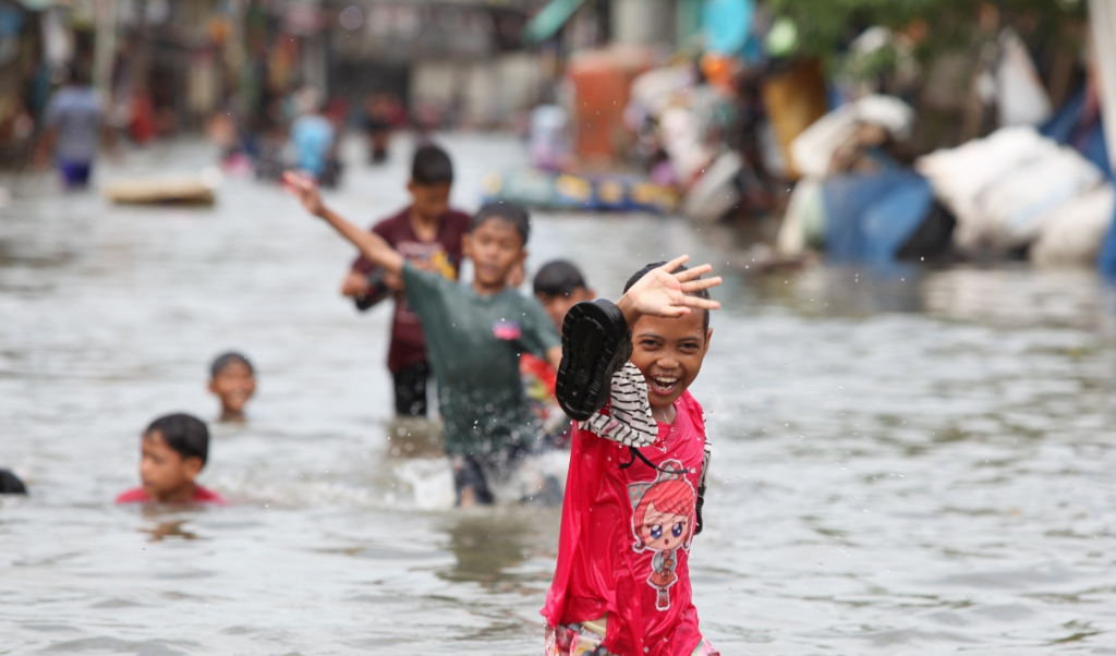 Sejumlah anak bermain di tengah banjir rob di Muara Angke, Jakarta, Senin (16/12/2024).  (Berita Nasional.com/Oke Atmaja)