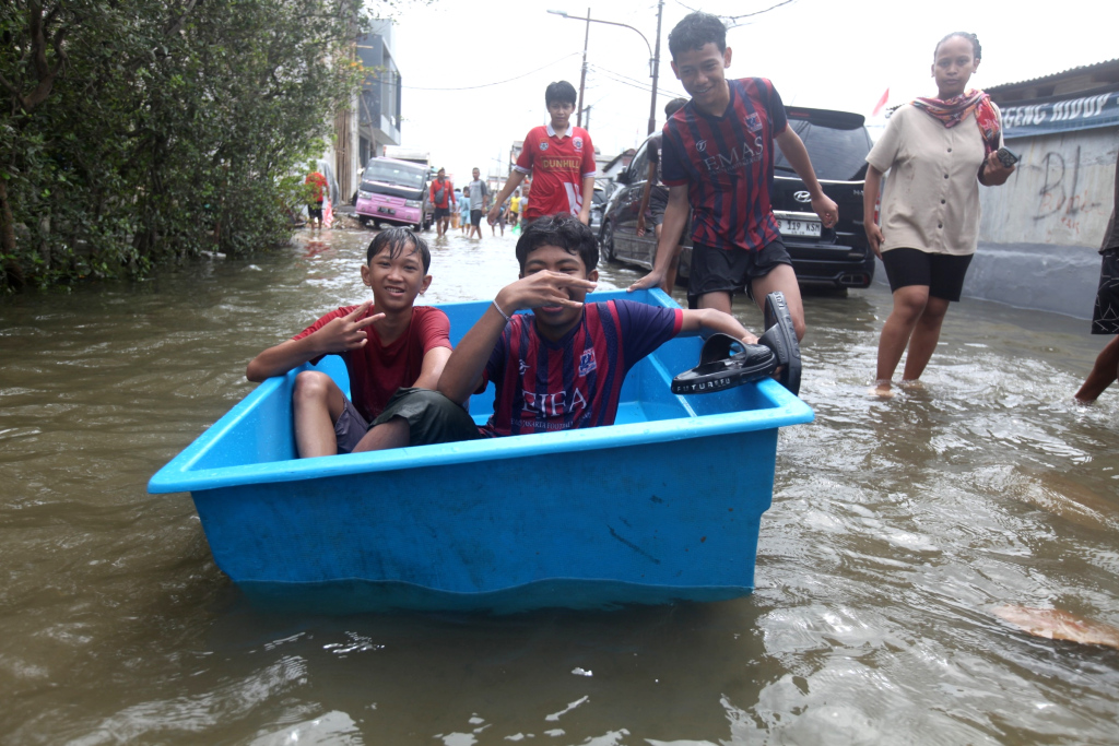 Sejumlah anak bermain di tengah banjir rob di Muara Angke, Jakarta, Senin (16/12/2024).  (Berita Nasional.com/Oke Atmaja)