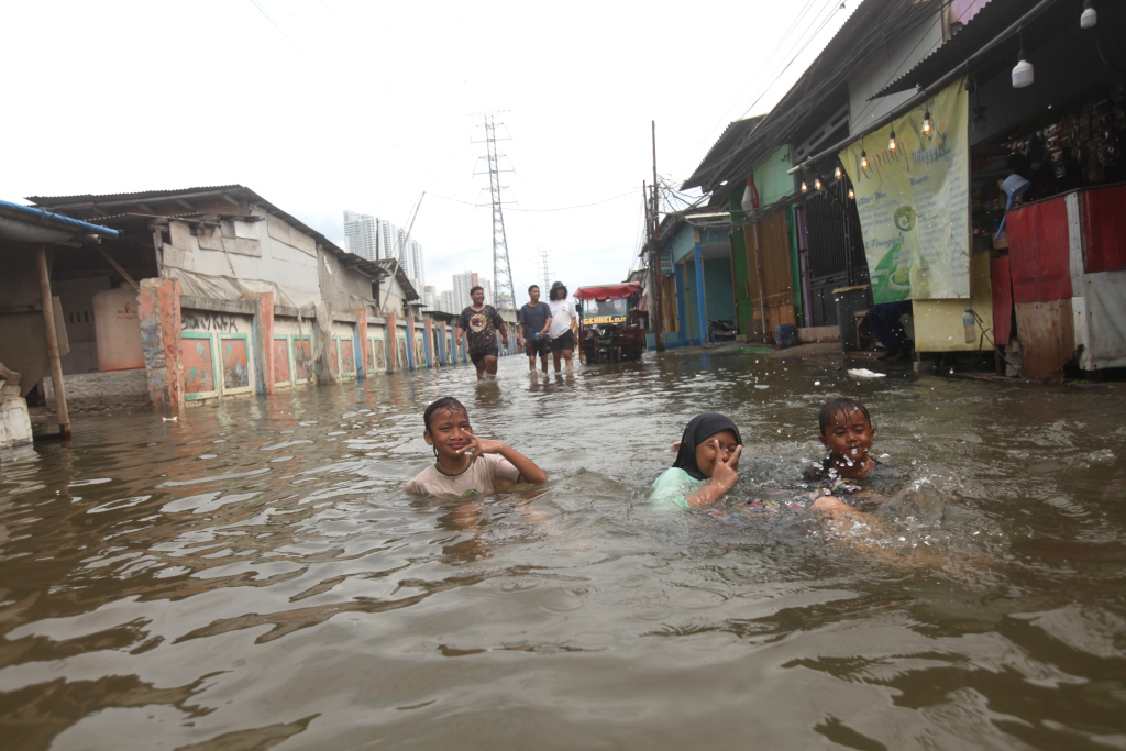 Sejumlah anak bermain di tengah banjir rob di Muara Angke, Jakarta, Senin (16/12/2024).  (Berita Nasional.com/Oke Atmaja)