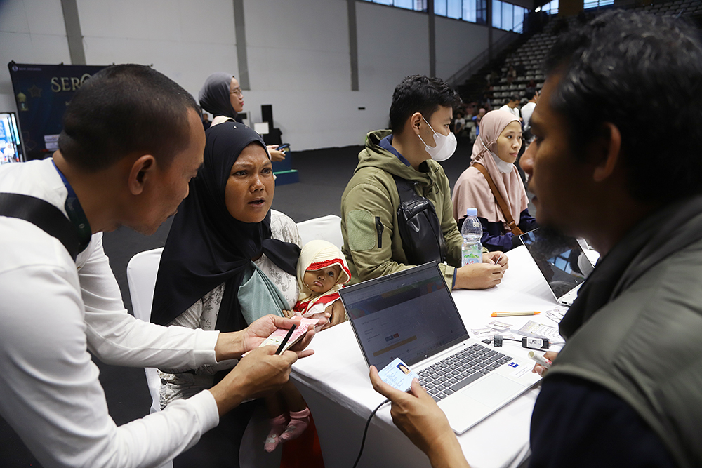 Pekerja Bank melayani warga yang ingin menukarkan uang baru di Jakarta. (BeritaNasional/Elvis Sendouw)