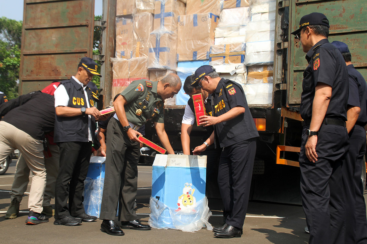 Petugas menggunakan alat berat eskavator saat memusnahkan minuman keras ilegal hasil penindakan di Kantor Pusat Bea Cukai, Jakarta Timur,Rabu (31/7/2024). (BeritaNasional.com/Oke Atmaja)