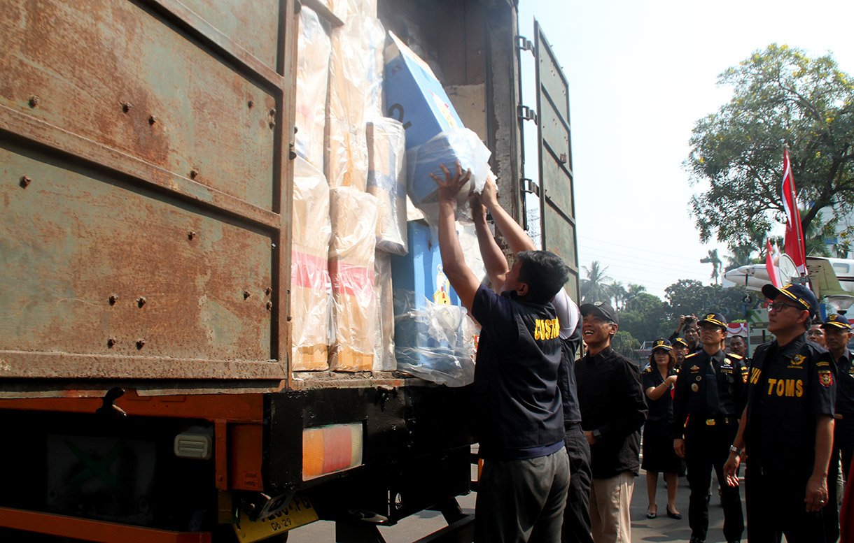 Petugas menggunakan alat berat eskavator saat memusnahkan minuman keras ilegal hasil penindakan di Kantor Pusat Bea Cukai, Jakarta Timur,Rabu (31/7/2024). (BeritaNasional.com/Oke Atmaja)