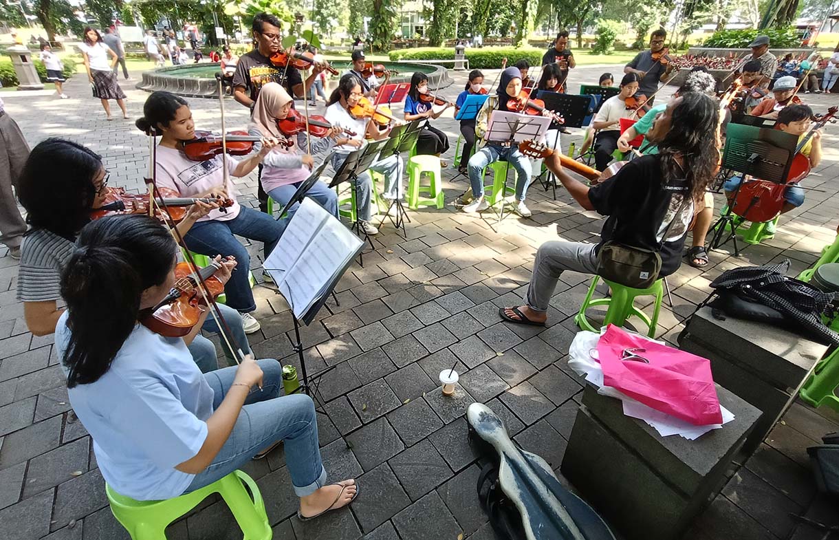 Warga bermain alat musik biola di Taman Suropati, Jakarta, Minggu (19/1/2024).  (BeritaNasional.com/Oke Atmaja)