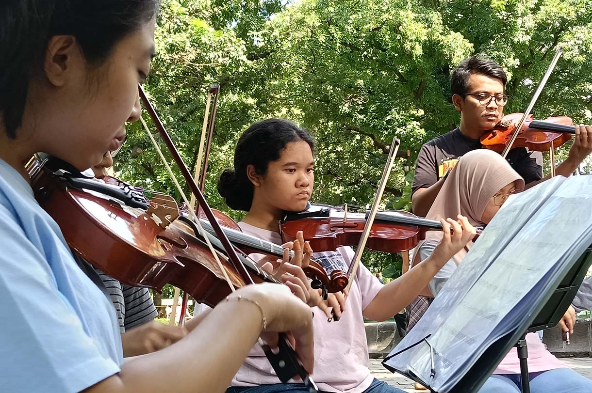 Warga bermain alat musik biola di Taman Suropati, Jakarta, Minggu (19/1/2024).  (BeritaNasional.com/Oke Atmaja)