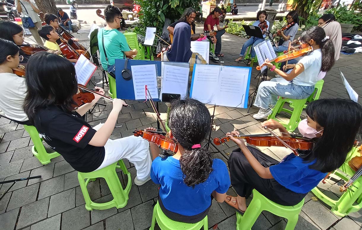 Warga bermain alat musik biola di Taman Suropati, Jakarta, Minggu (19/1/2024).  (BeritaNasional.com/Oke Atmaja)