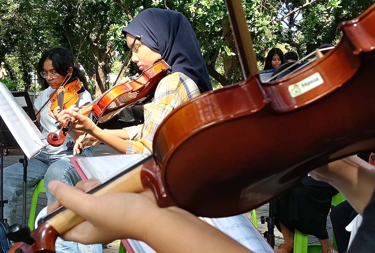 Warga bermain alat musik biola di Taman Suropati, Jakarta, Minggu (19/1/2024).  (BeritaNasional.com/Oke Atmaja)