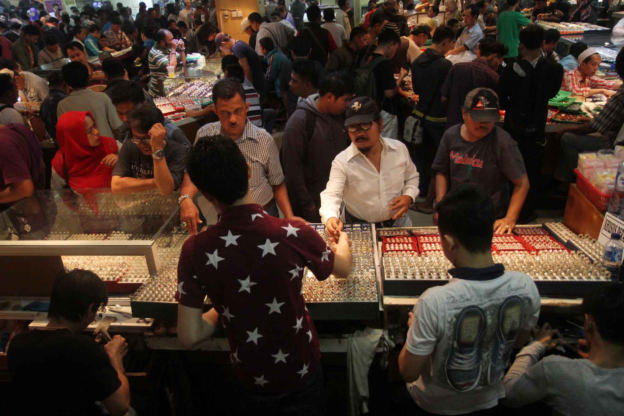 Pedagang menata batu akik yang dijual di Pasar Rawa Bening, Jakarta, Kamis (18/4/2024).(BeritaNasional.com/Oke Atmaja)