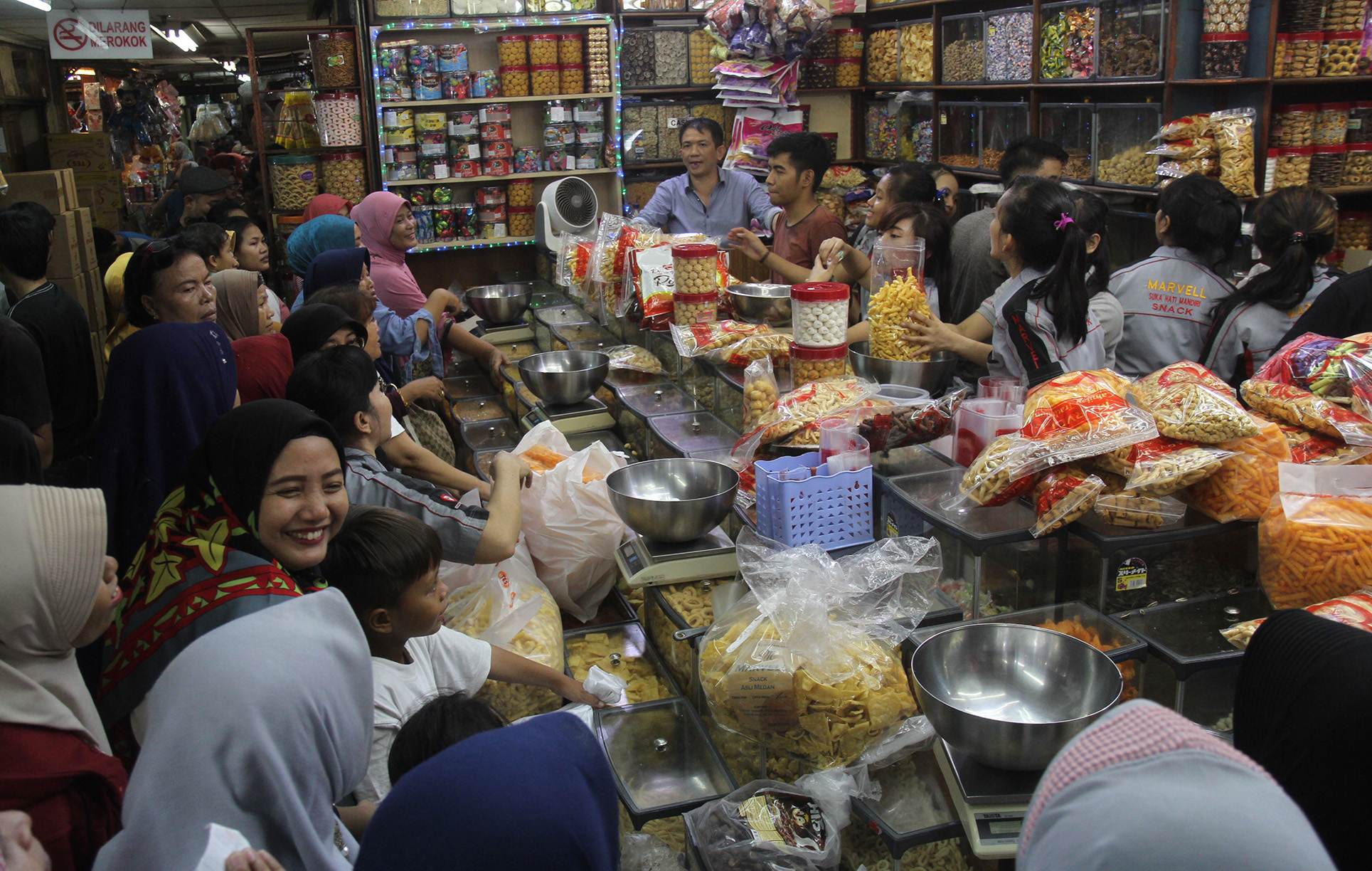 Warga mengantre membeli kue kering di pasar Jatinegara, Jakarta, Kamis (28/3). (Indonesiaglobe/Oke Atmaja)