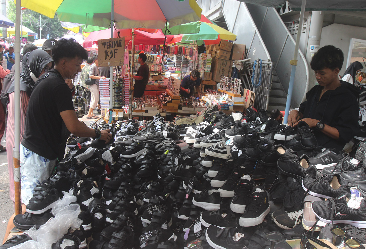 Pedagang melayani warga membeli alat tulis di Pasar Pagi Esemka,Jakarta, Kamis (4/7/2024). (BeritaNasional.com/Oke Atmaja)