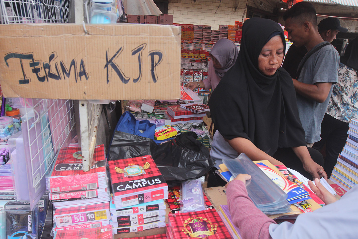 Pedagang melayani warga membeli alat tulis di Pasar Pagi Esemka,Jakarta, Kamis (4/7/2024). (BeritaNasional.com/Oke Atmaja)