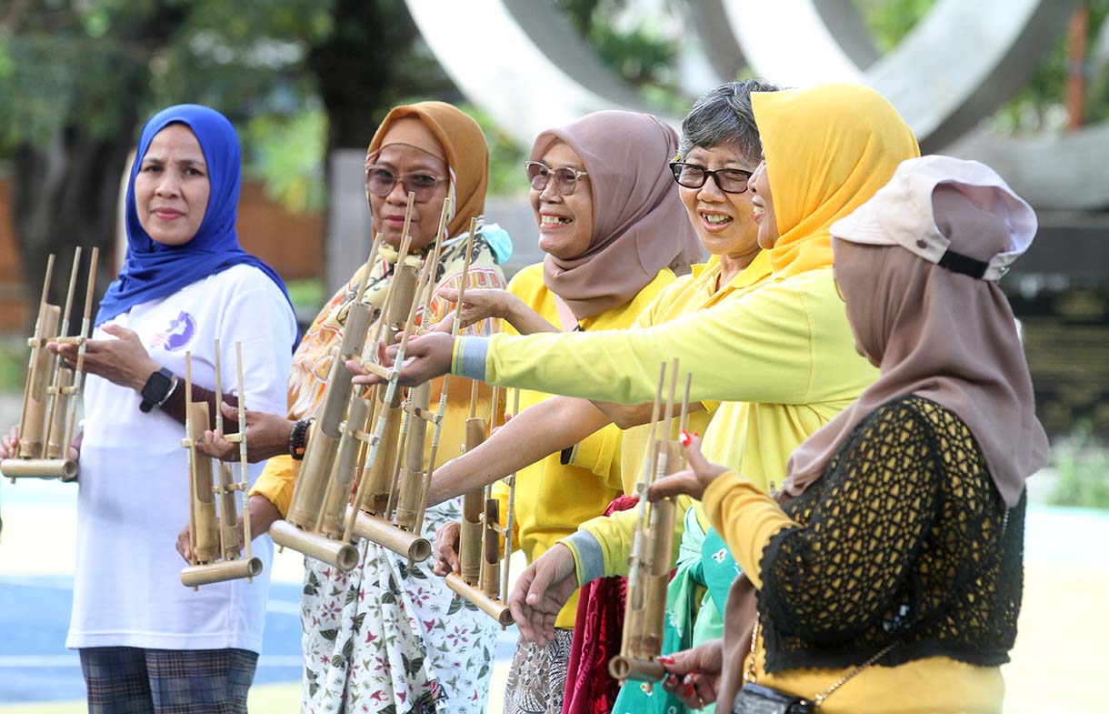 Warga memainkan alat music tradisional angklung di Taman Menteng, Jakarta, Minggu (25/5/2025). (Beritanasional.com/Oke Atmaja)