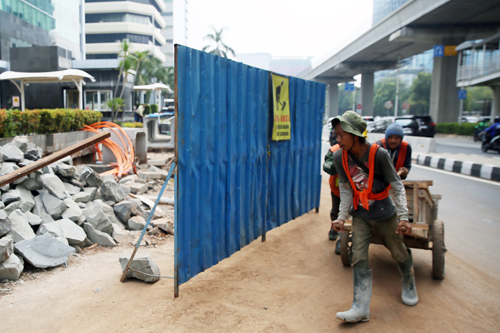 Pekerja menyelesaikan trotoar jalan Rasuna Said Jakarta Selatan. (BeritaNasional/Elvis Sendouw)