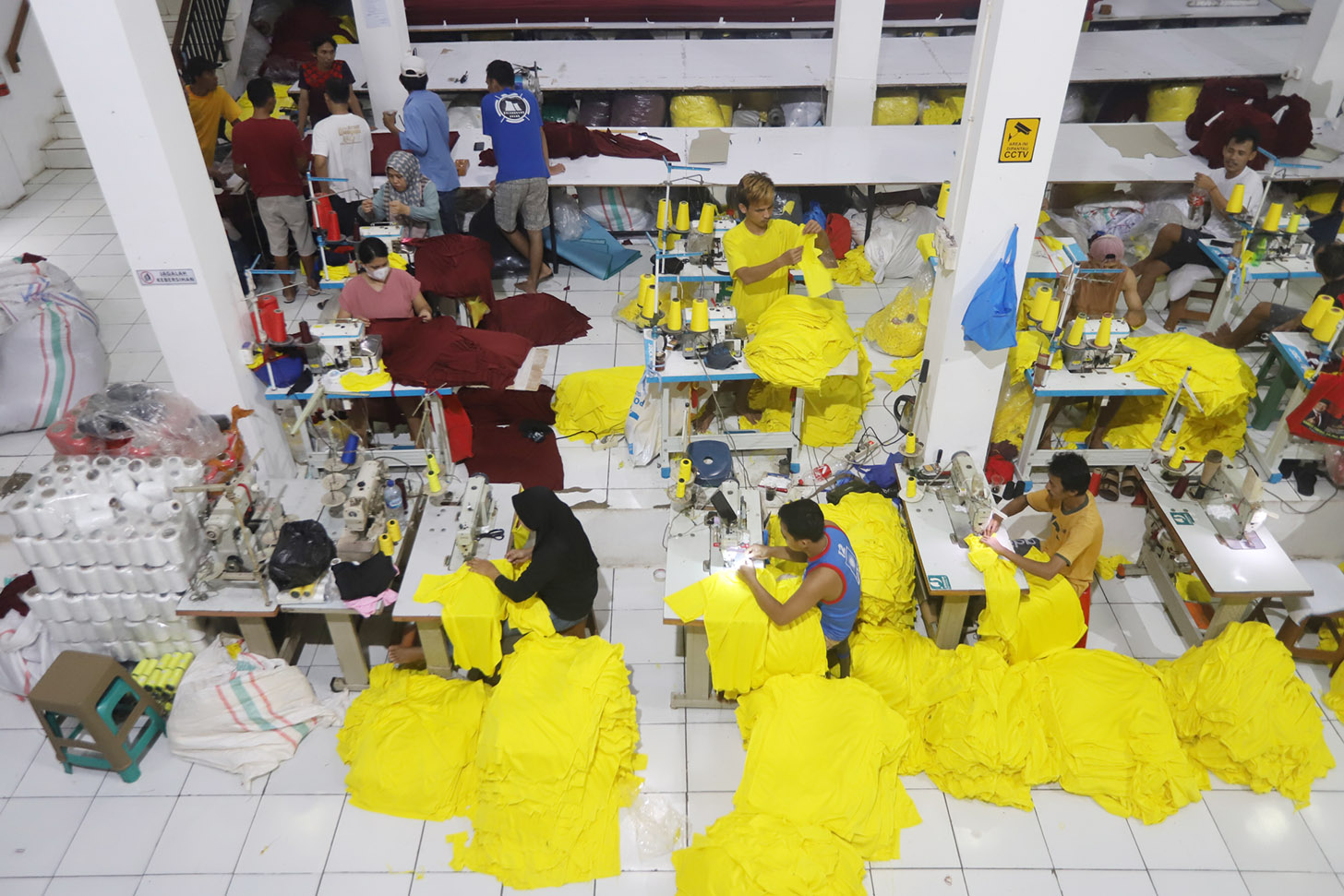 Sejumlah pekerja menjahit pesanan kaos di  konveksi Sinergi Adv, kawasan Srengseng Sawah, Jakarta, Minggu (7/7/2024). (BeritaNasional.com/Oke Atmaja)