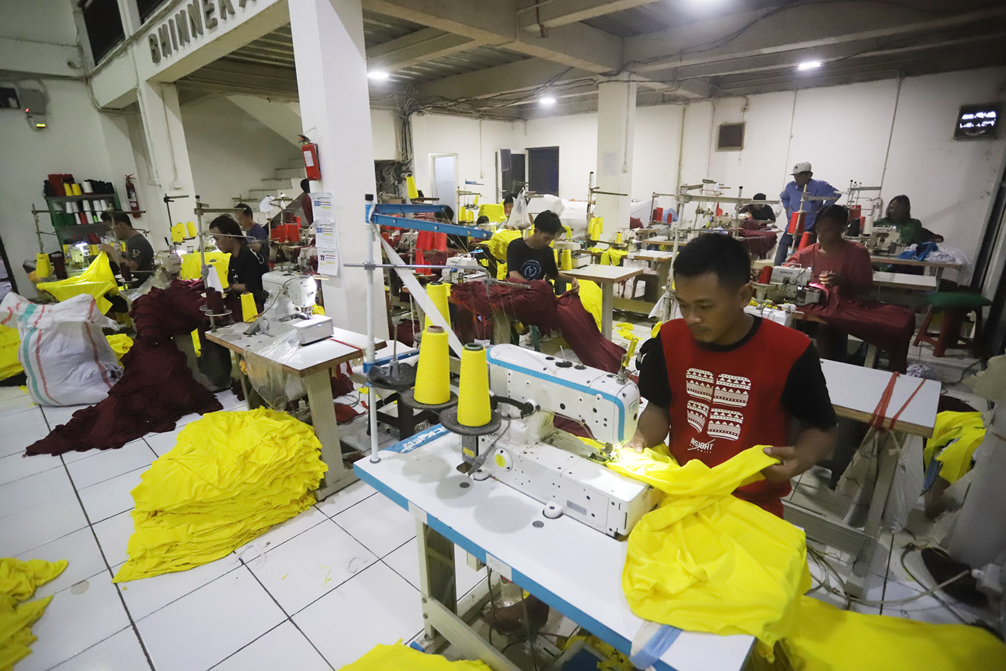 Sejumlah pekerja menjahit pesanan kaos di  konveksi Sinergi Adv, kawasan Srengseng Sawah, Jakarta, Minggu (7/7/2024). (BeritaNasional.com/Oke Atmaja)