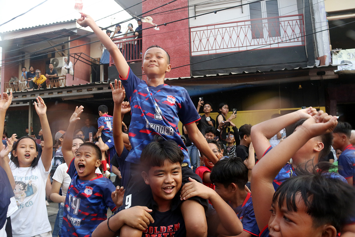 Sejumlah anak yang tergabung dalam tim Blue Lion mengangkat piala usai bertanding pada Liga Aspal di kawasan Menteng, Jakarta, Sabtu (18/7/2026). (Beritanasional.com/Oke Atmaja)