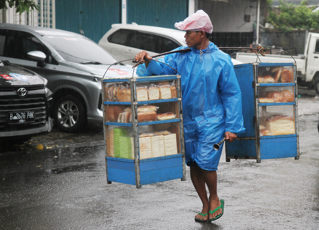 Warga melintas saat hujan di Jalan Minang Kabau, Jakarta, Selasa (12/8/2025).(Beritanasional.com/Oke Atmaja)