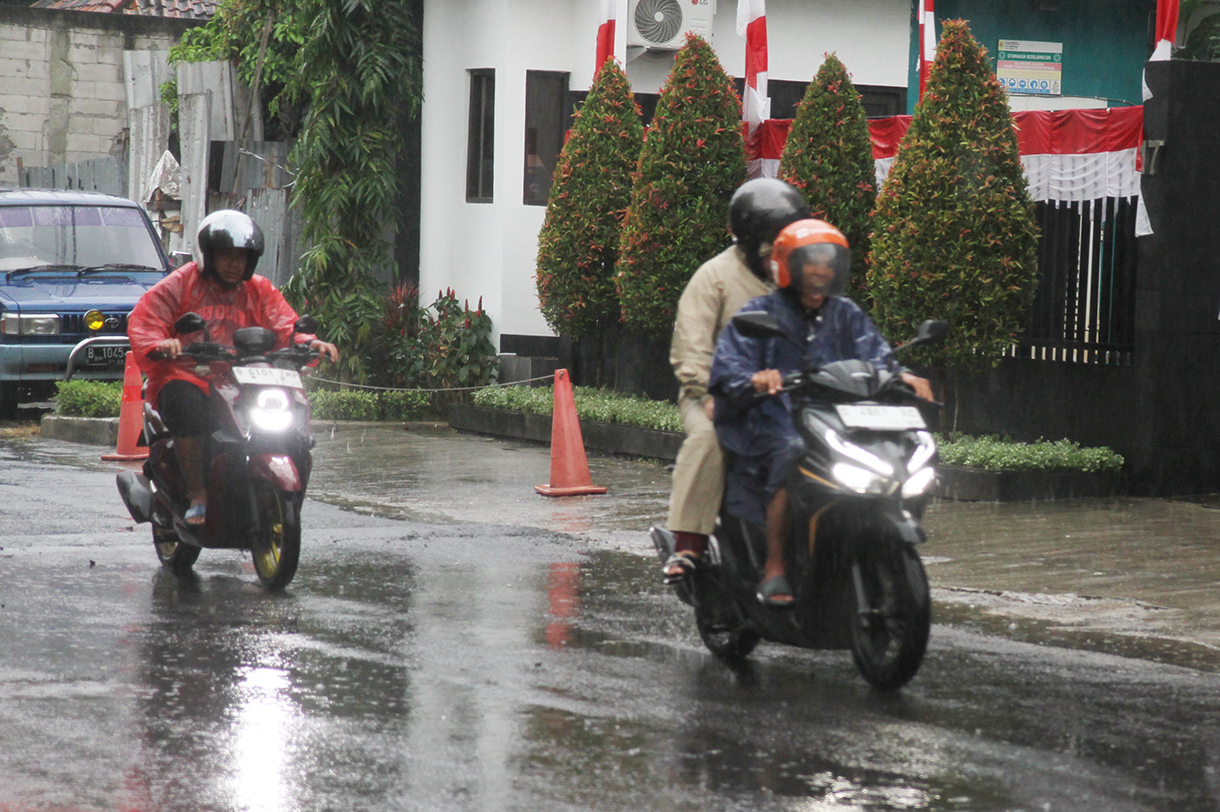 Warga melintas saat hujan di Jalan Minang Kabau, Jakarta, Selasa (12/8/2025).(Beritanasional.com/Oke Atmaja)