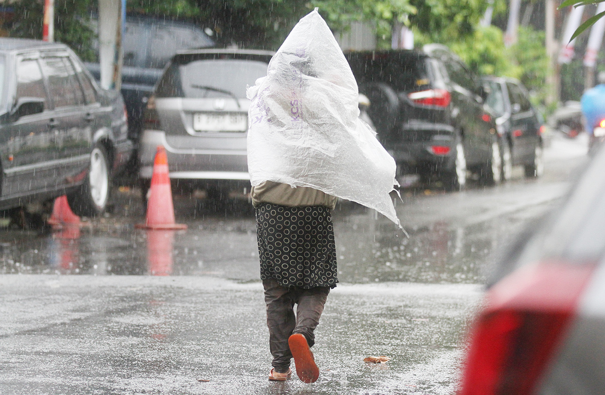 Warga melintas saat hujan di Jalan Minang Kabau, Jakarta, Selasa (12/8/2025).(Beritanasional.com/Oke Atmaja)