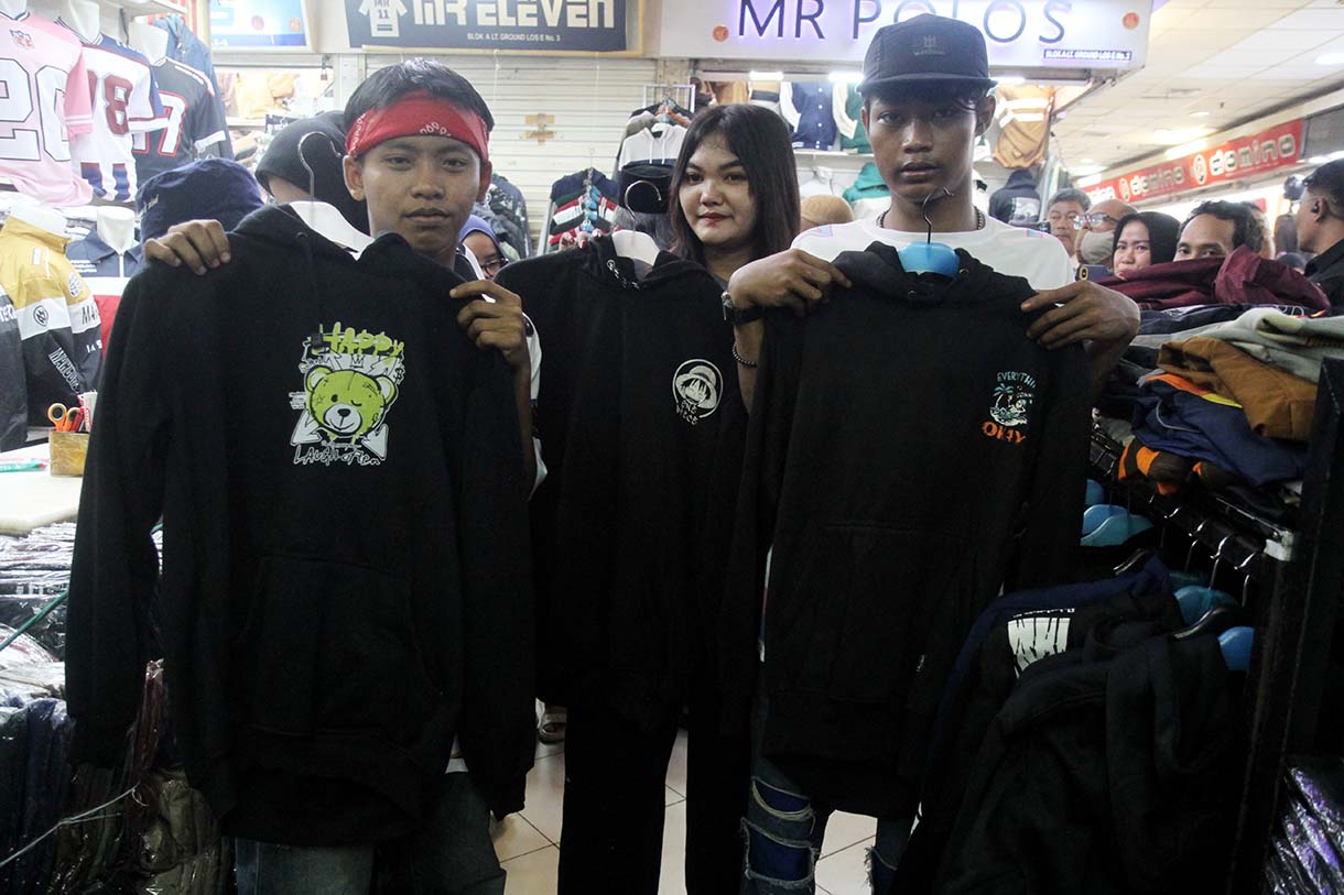 Personel Geng Citayam Fashion Week Bonge, Kurma dan Roy bersama CEO Sinergi ADV Nusantara H.Prama Tirta (kedua kiri) berbelanja produk lokal topi di Pasar Blok A Tanah Abang, Jakarta, Senin (12/5/2025).(Beritanasional.com/Oke Atmaja)