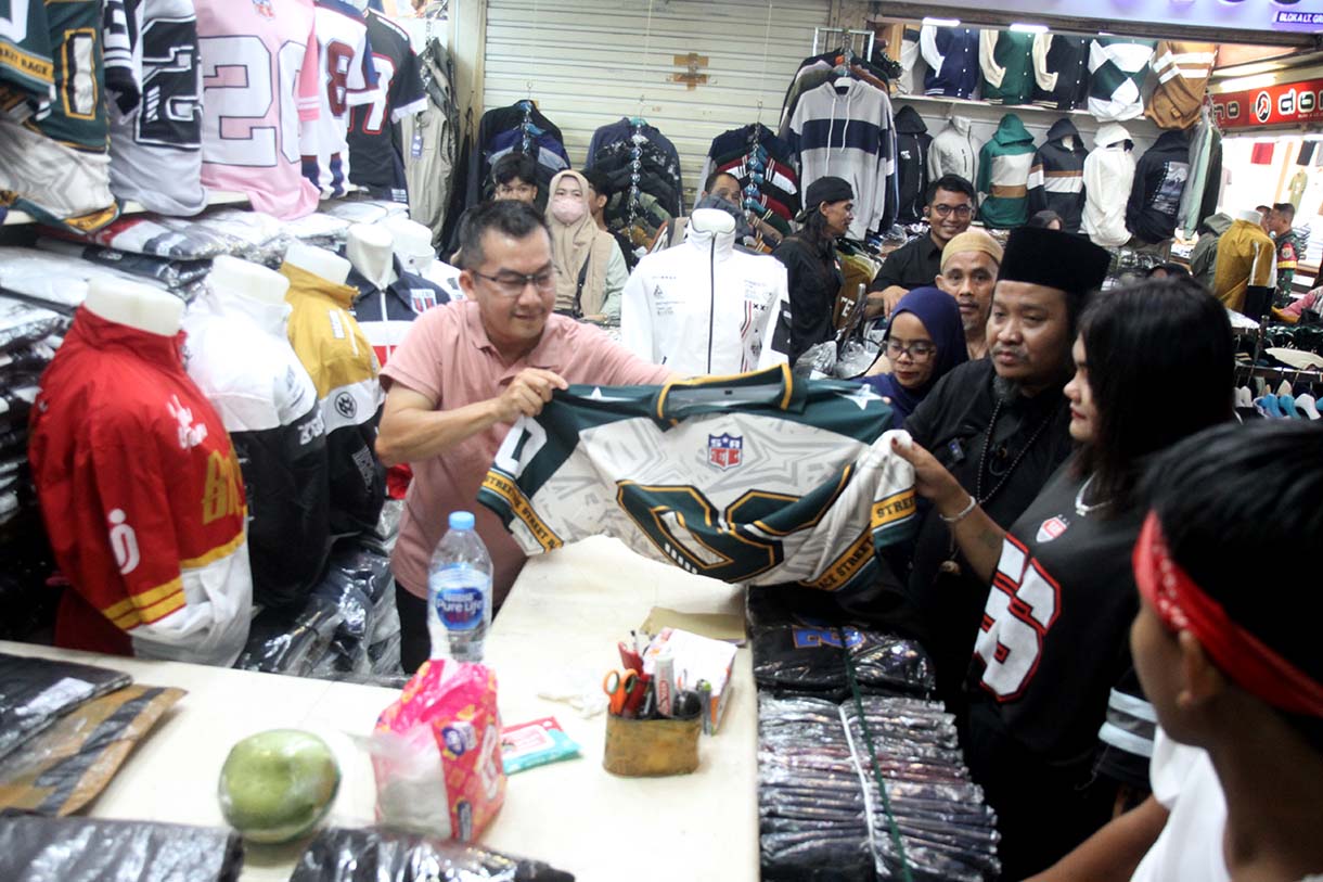 Personel Geng Citayam Fashion Week Bonge, Kurma dan Roy bersama CEO Sinergi ADV Nusantara H.Prama Tirta (kedua kiri) berbelanja produk lokal topi di Pasar Blok A Tanah Abang, Jakarta, Senin (12/5/2025).(Beritanasional.com/Oke Atmaja)