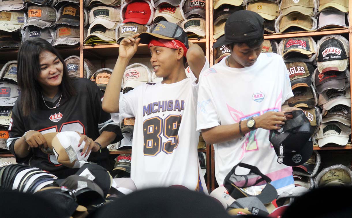 Personel Geng Citayam Fashion Week Bonge, Kurma dan Roy bersama CEO Sinergi ADV Nusantara H.Prama Tirta (kedua kiri) berbelanja produk lokal topi di Pasar Blok A Tanah Abang, Jakarta, Senin (12/5/2025).(Beritanasional.com/Oke Atmaja)