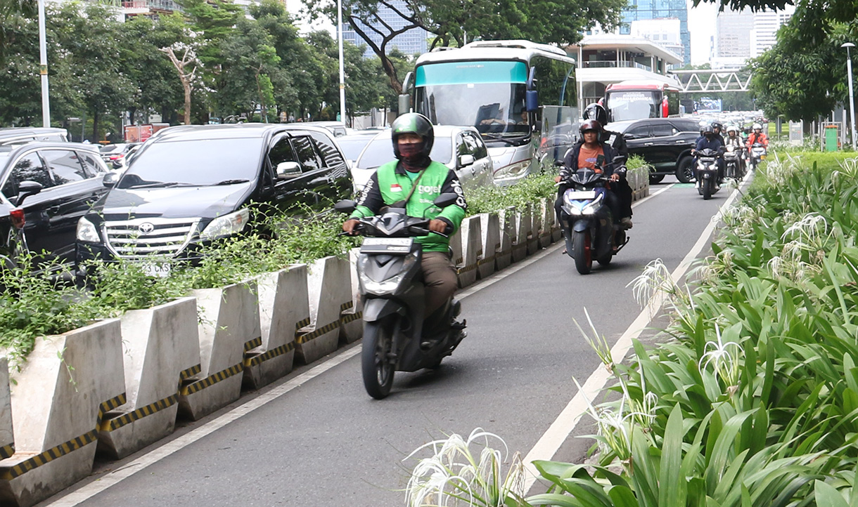 Sejumlah pengemudi ojek online (ojol) melintas di Kawasan Jalan Sudirman-Thamrin, Kawasan Senayan, Jakarta, Rabu (4/3/2026).(Beritanasional.com/Oke Atmaja)