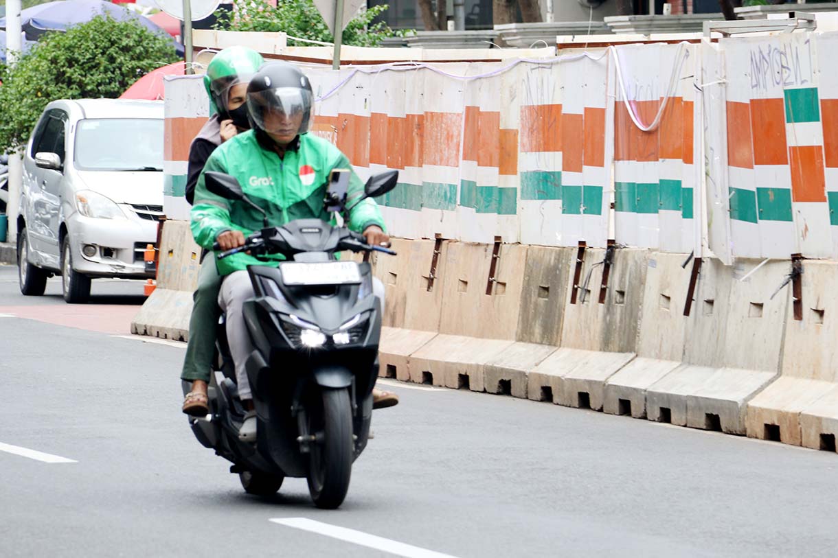 Pengemudi ojek online (ojol) mengangkut penumpang dan melintas di kawasan Stasiun Cikini, Jakarta, Sabtu (20/9/2025).  (Beritanasional.com/Oke Atmaja)