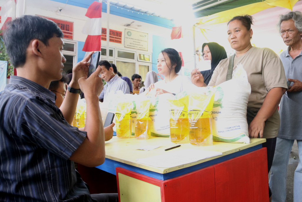 Warga memikul beras usai mengambil bantuan pangan gratis di Balai RW 03 Kelurahan Menteng, Jakarta, Rabu, (12/11/2025). (Berita nasional.com/Oke Atmaja)