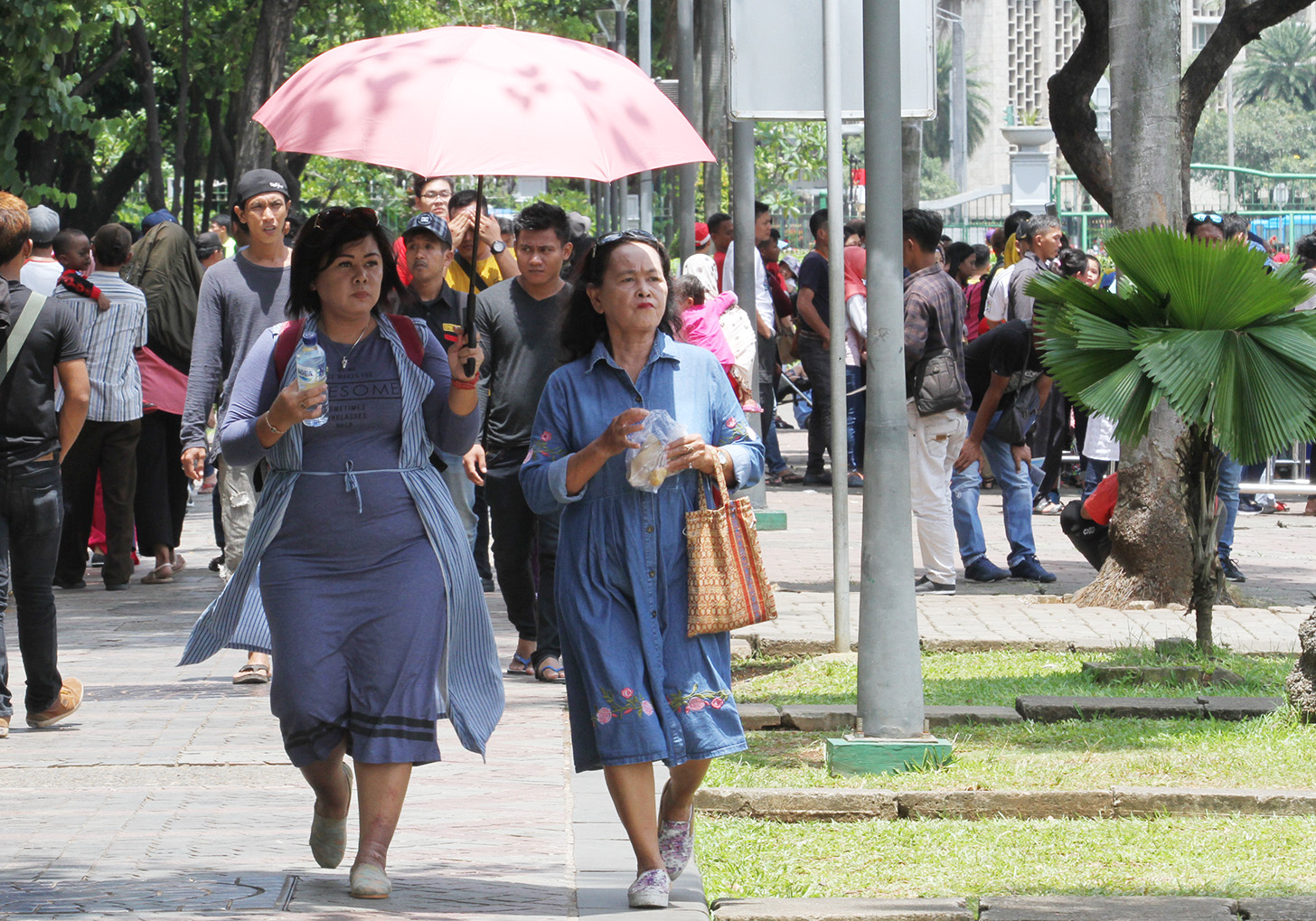 Warga berjalan di Monumen Nasional (Monas), Jakarta, Sabtu (18/5/2024).  (BeritaNasional.com/Oke Atmaja)