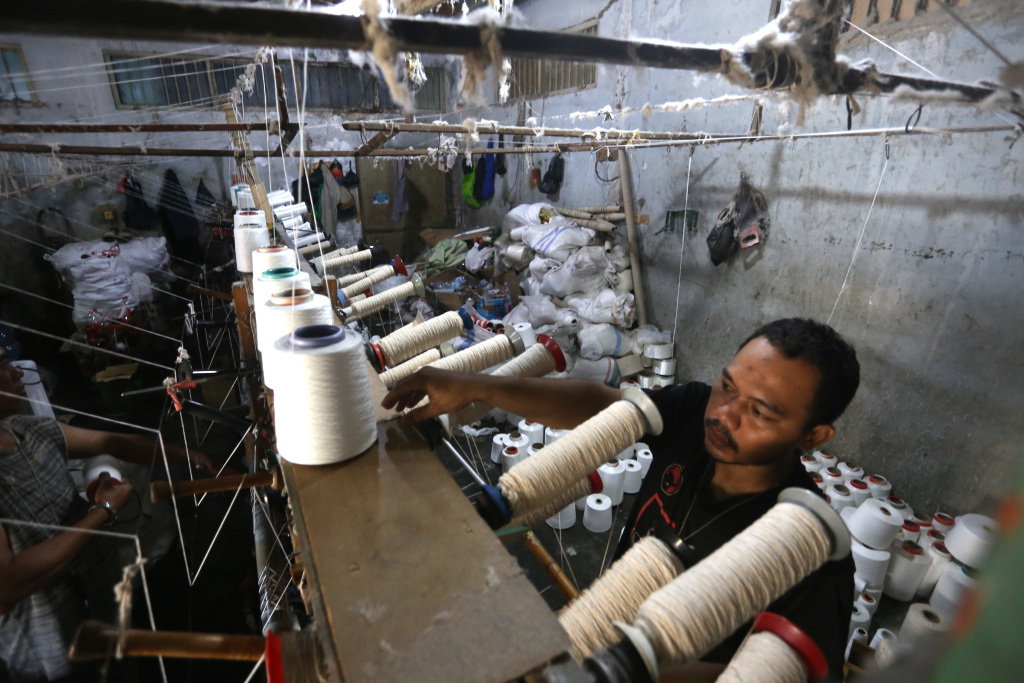 Aktivitas pekerja memintal benang sebagai bahan baku tekstil di Karta Ajies Garment, Kebayoran Lama, Jakarta Selatan, Kamis (16/4/2026). (Beritaasional.com/Oke Atmaja)