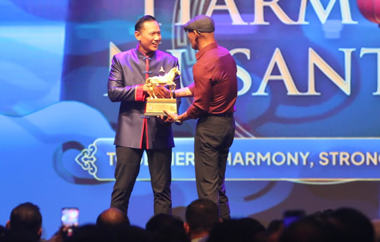Ketua Umum Partai Demokrat Agus Harimurti Yudhoyono (kiri) memberikan penghargaan kepada Stafsus Menhan Bidang Komunikasi dan Publik Deddy Corbuzier saat Perayaan Imlek Nasional bertema Harmoni Nusantara di Djakarta Theater, Jakarta, Rabu (18/2/2026).(Beritanasional.com/Oke Atmaja)