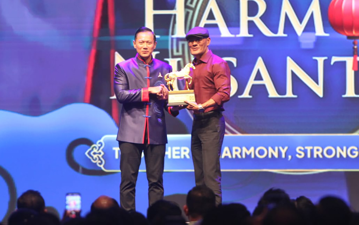Ketua Umum Partai Demokrat Agus Harimurti Yudhoyono (kiri) memberikan penghargaan kepada Stafsus Menhan Bidang Komunikasi dan Publik Deddy Corbuzier saat Perayaan Imlek Nasional bertema Harmoni Nusantara di Djakarta Theater, Jakarta, Rabu (18/2/2026).(Beritanasional.com/Oke Atmaja)