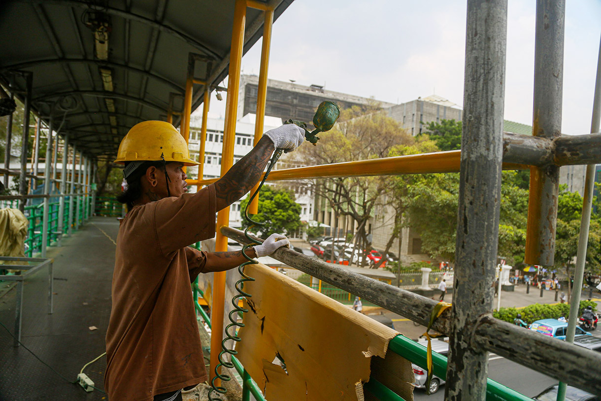 Para pekerja menggarap revitaliasai jembatan penyeberangan orang (JPO) di kawasan Salemba, Jakarta, Jumat, (11/10/2024).(BeritaNasional.com/Oke Atmaja)