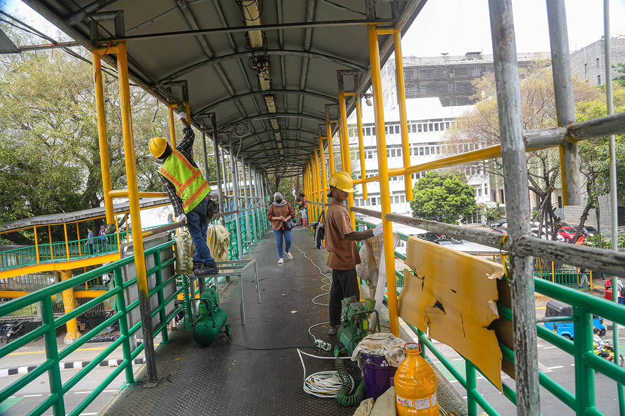 Para pekerja menggarap revitaliasai jembatan penyeberangan orang (JPO) di kawasan Salemba, Jakarta, Jumat, (11/10/2024).(BeritaNasional.com/Oke Atmaja)