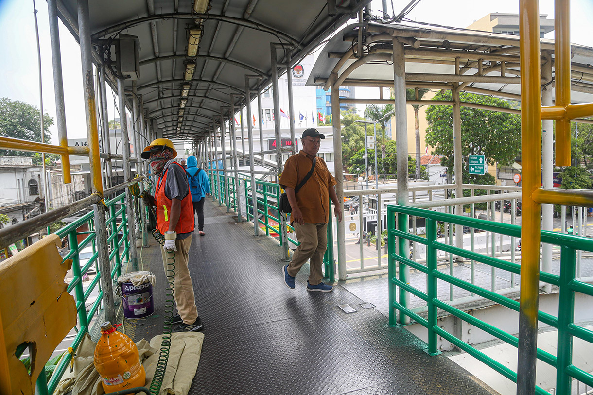 Para pekerja menggarap revitaliasai jembatan penyeberangan orang (JPO) di kawasan Salemba, Jakarta, Jumat, (11/10/2024).(BeritaNasional.com/Oke Atmaja)