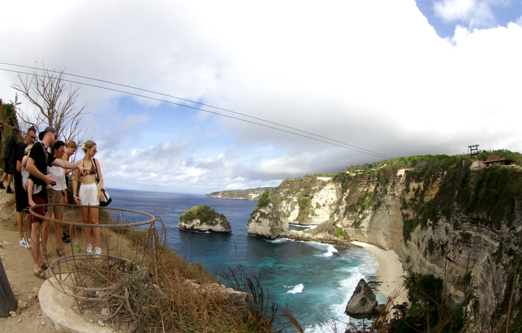 Pengunjung berfoto berlatar pantai Diamond Beach di Nusa Penida, Bali, Minggu (2/6/2024).  (BeritaNasional.Com/Oke Atmaja)