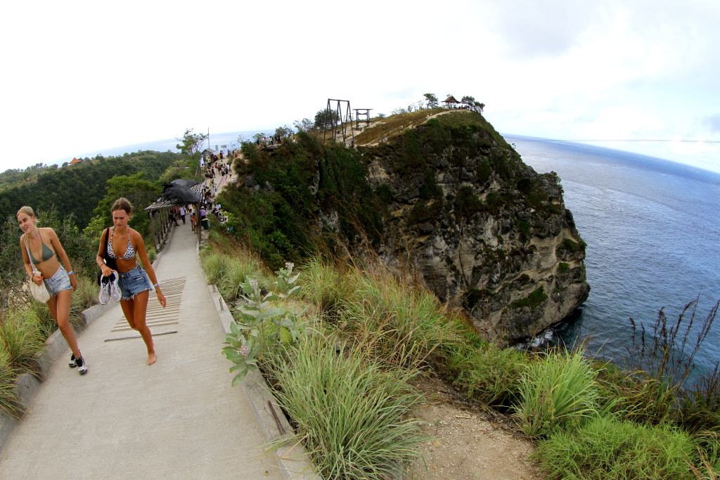 Pengunjung berfoto berlatar pantai Diamond Beach di Nusa Penida, Bali, Minggu (2/6/2024).  (BeritaNasional.Com/Oke Atmaja)