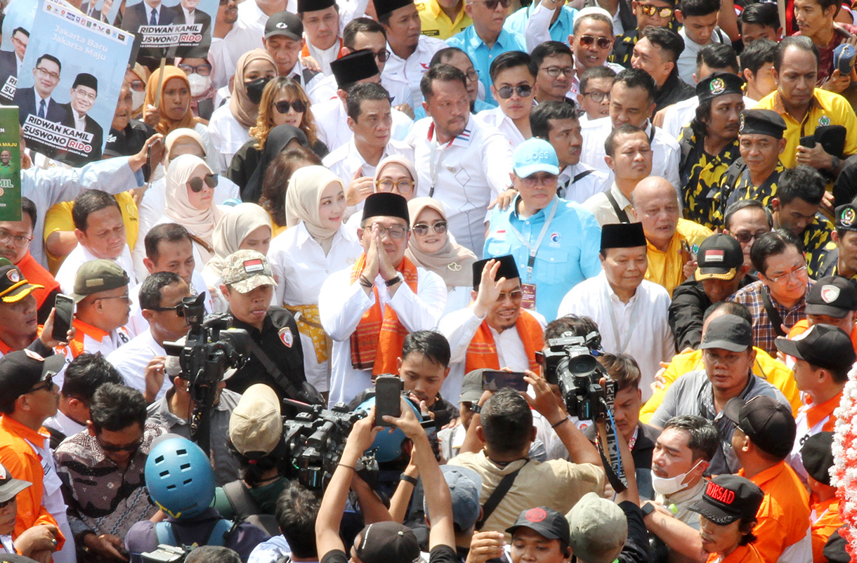 Pasangan bakal calon Gubernur DKI Jakarta Ridwan Kamil (tengah) dan bakal calon Wakil Gubernur DKI Jakarta Suswono menyapa warga dan para pendukung saat berjalan menuju Kantor KPU DKI Jakarta, Jalan Salemba Raya, Jakarta, Rabu (28/8/2024).(BeritaNasional.com/ Oke Atmaja)