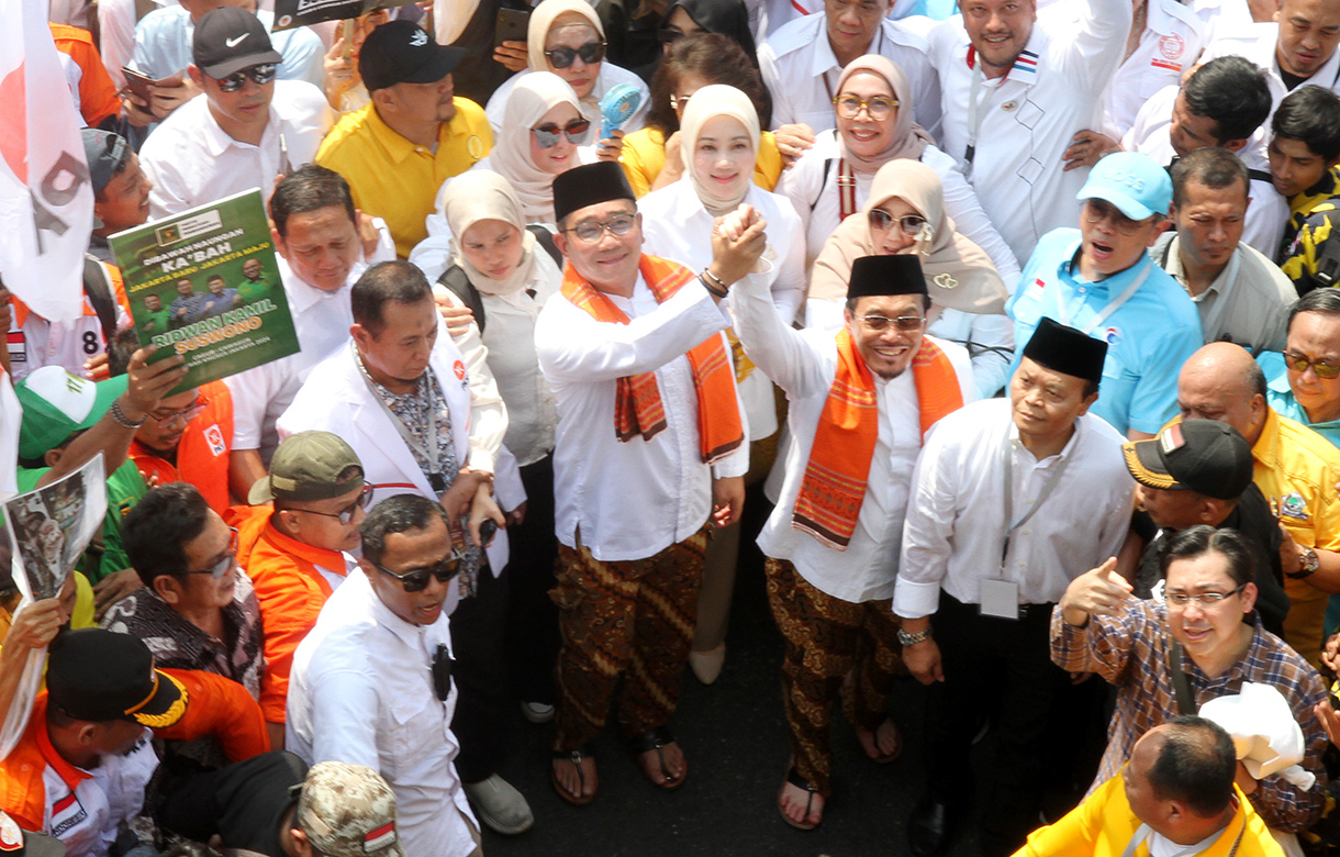 Pasangan bakal calon Gubernur DKI Jakarta Ridwan Kamil (tengah) dan bakal calon Wakil Gubernur DKI Jakarta Suswono menyapa warga dan para pendukung saat berjalan menuju Kantor KPU DKI Jakarta, Jalan Salemba Raya, Jakarta, Rabu (28/8/2024).(BeritaNasional.com/ Oke Atmaja)