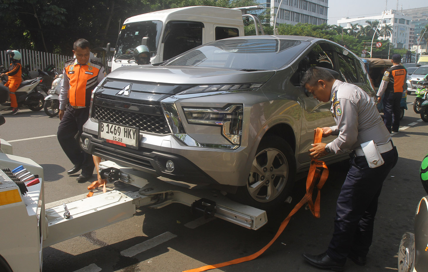 Petugas Dinas Perhubungan DKI Jakarta menderek sebuah mobil yang parkir sembarangan di Kawasan stasiun Gambir Jakarta, Selasa (28/5/2024). (BeritaNasional.Com/Oke Atmaja)